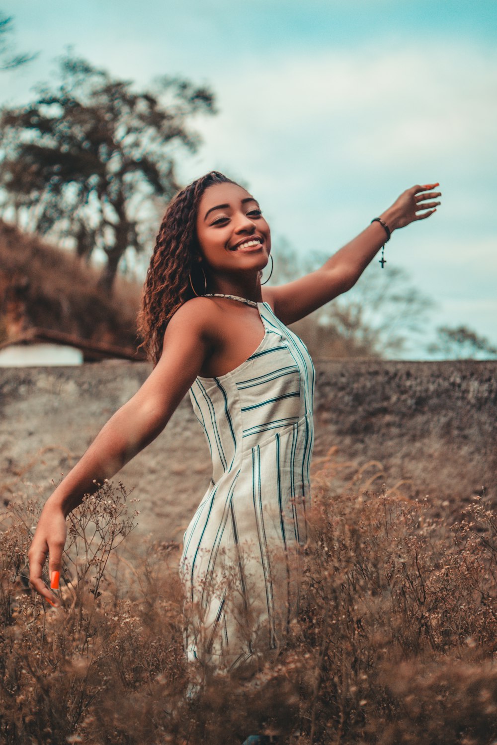 smiling woman standing beside plants during daytime