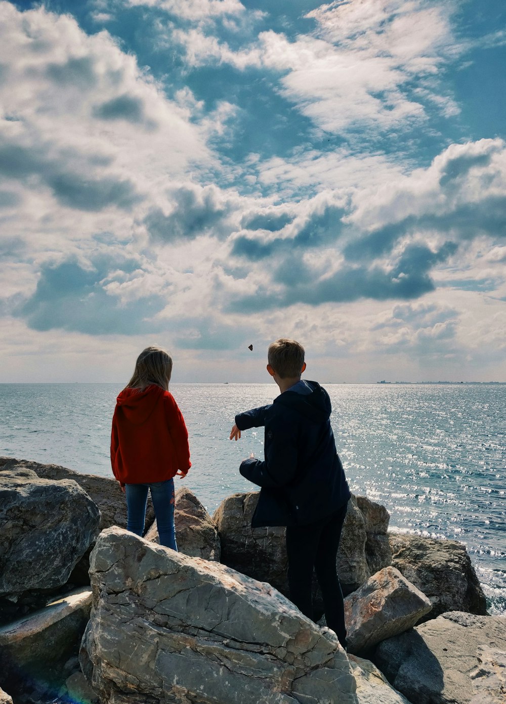 two person standing on rock