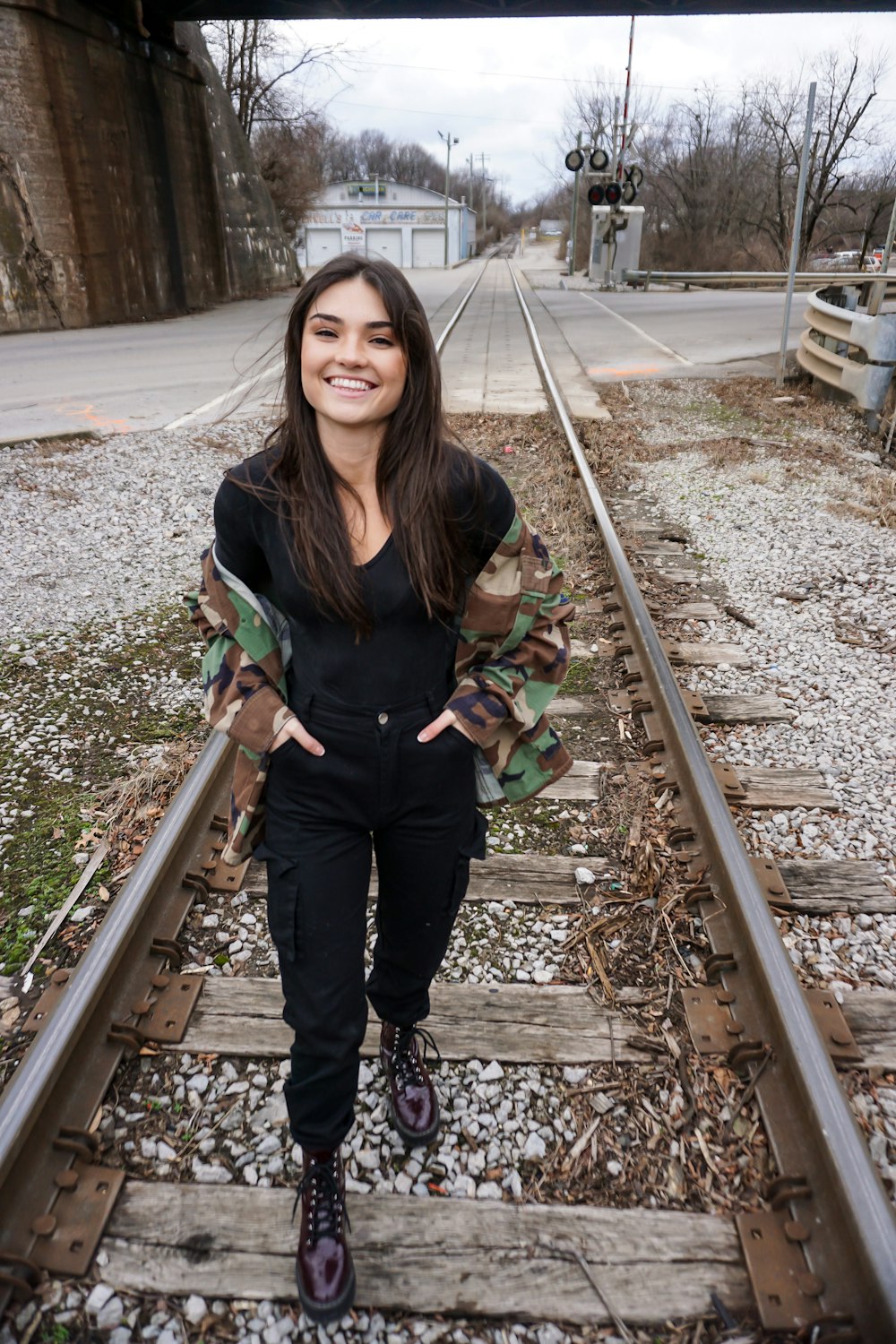 woman in black crew-neck shirt standing on train rail
