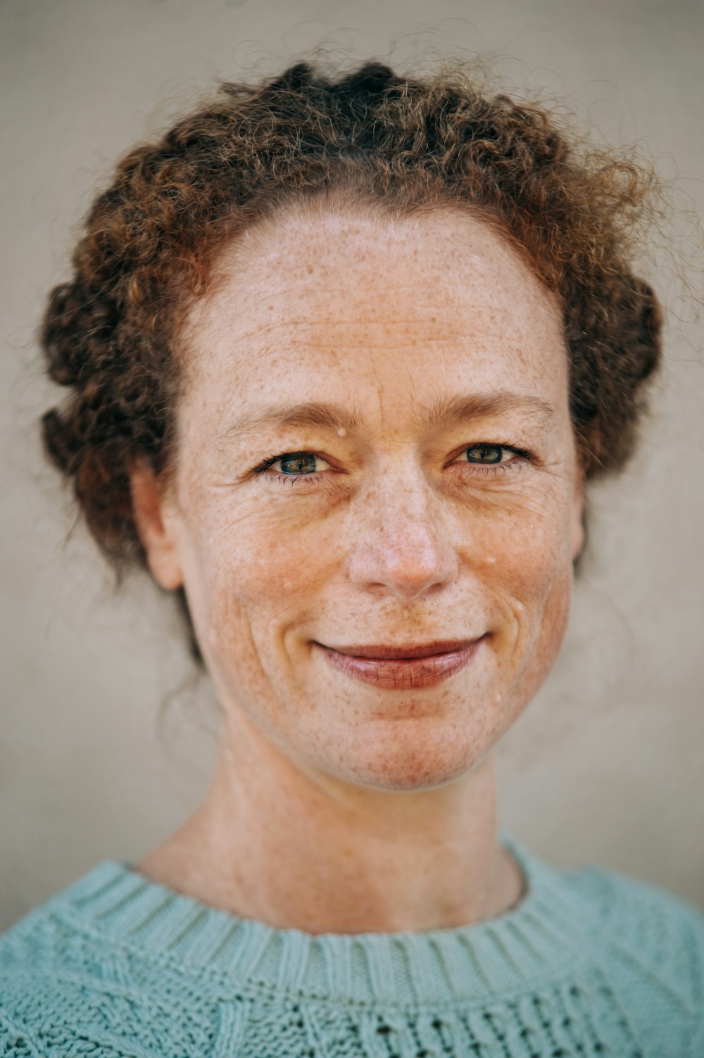 portrait photography of woman wearing crew-neck top smiling
