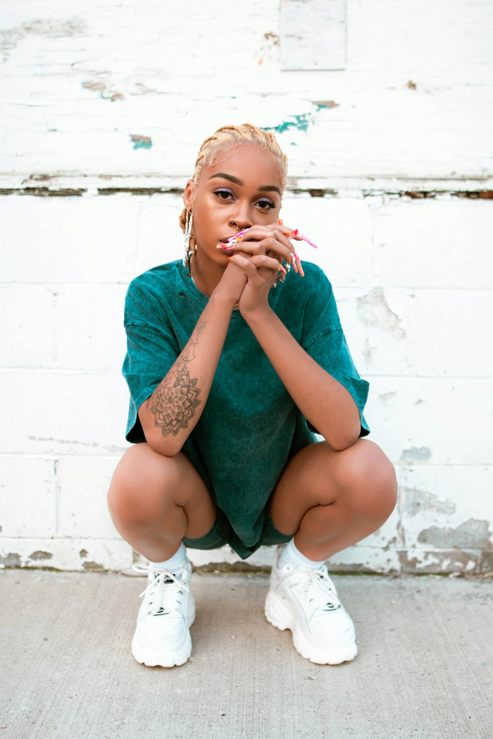 girl in teal shirt sitting on white plastic chair