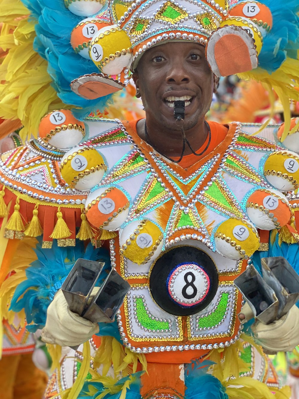 Hombre vestido con traje blanco, verde y naranja con etiqueta número 8