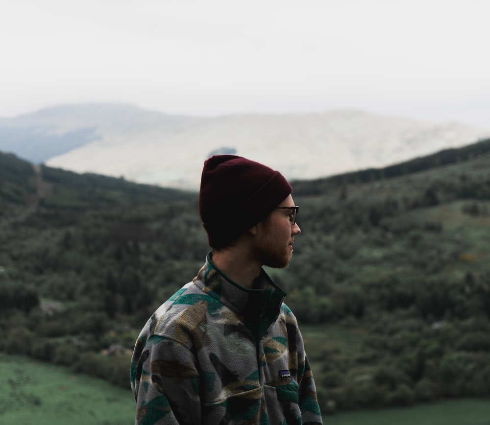 man facing to the side with mountain in the background