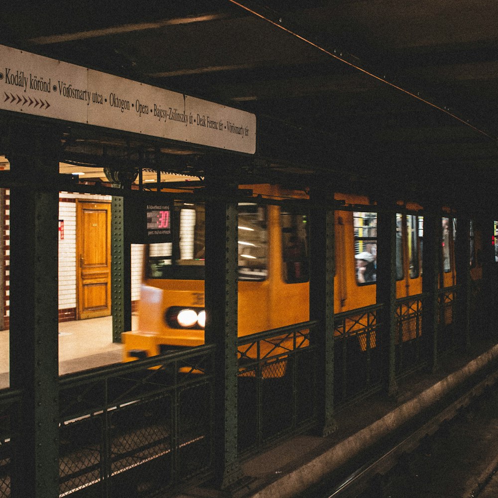 time-lapse photography of a yellow train passing in the station