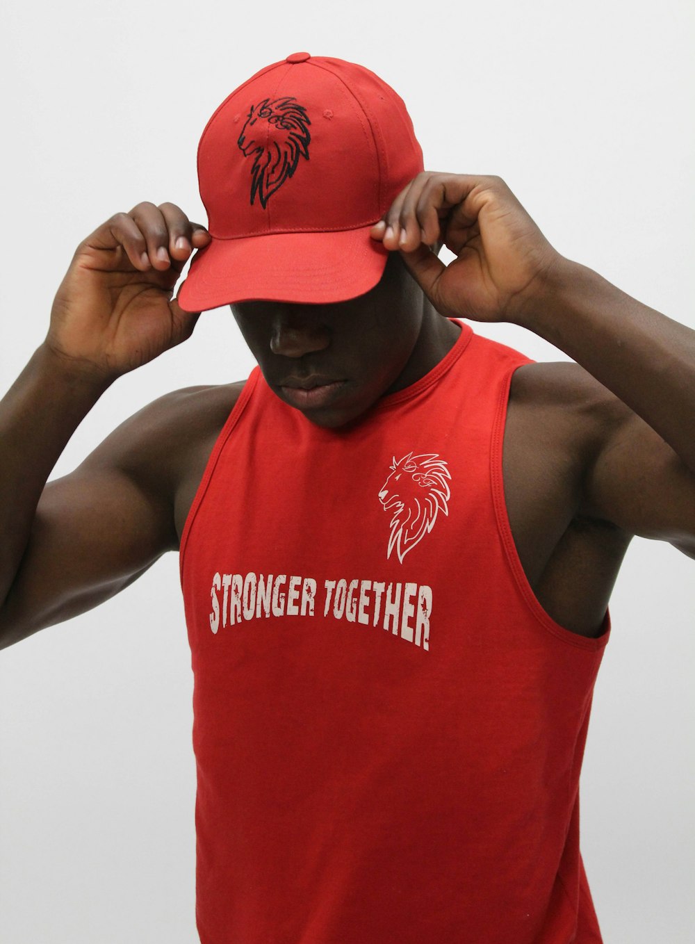 man wearing red tank top and cap