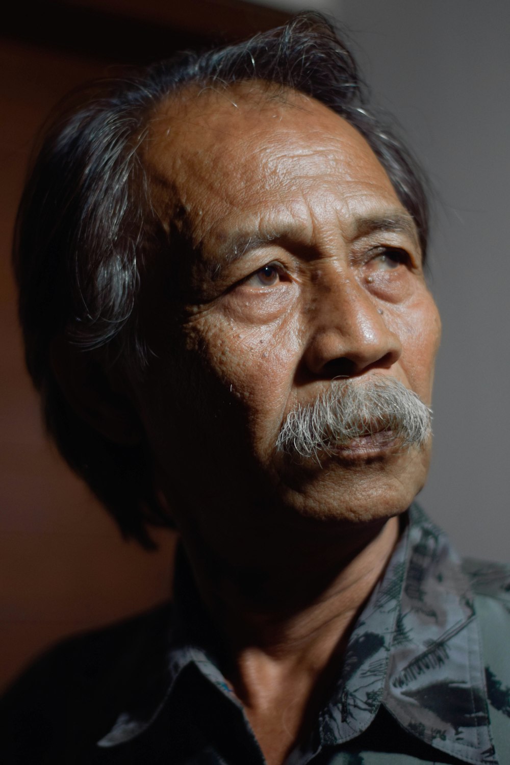 man in gray and black camouflage collared shirt