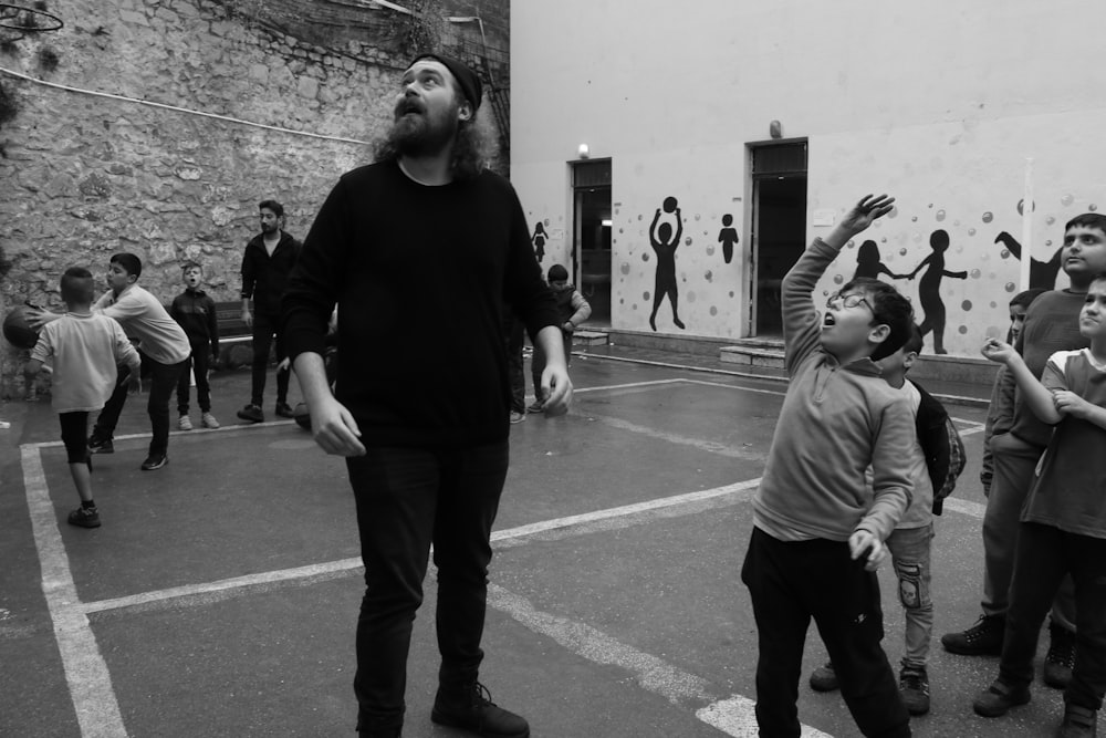 Photographie en niveaux de gris d’enfants et d’homme regardant vers le haut