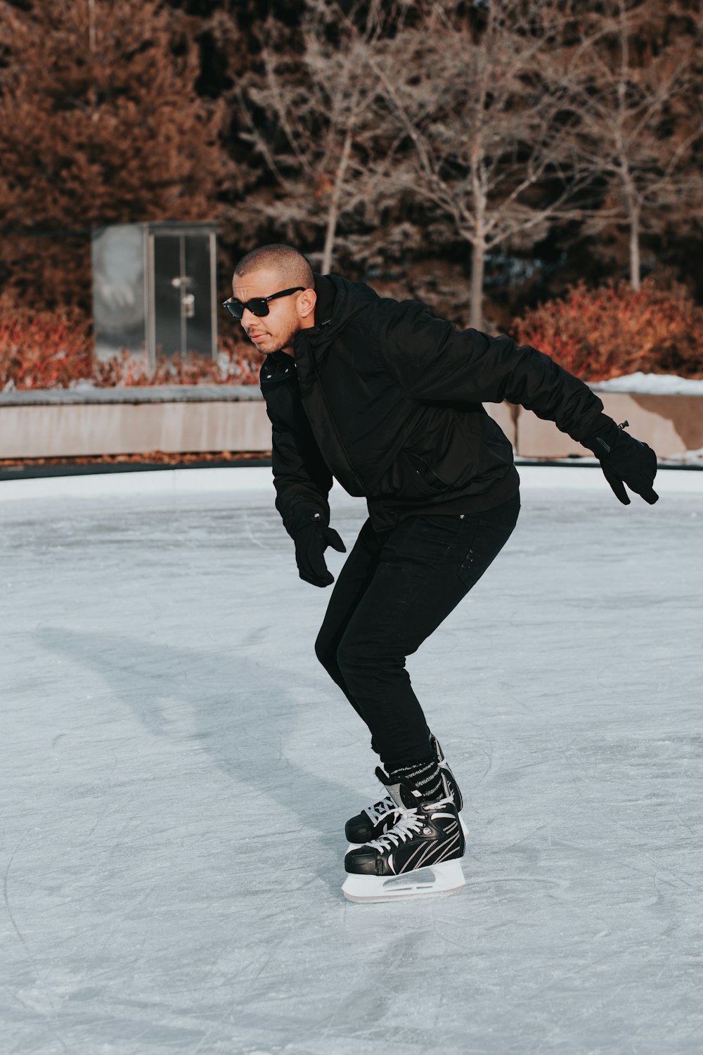 man in black jacket ice skating