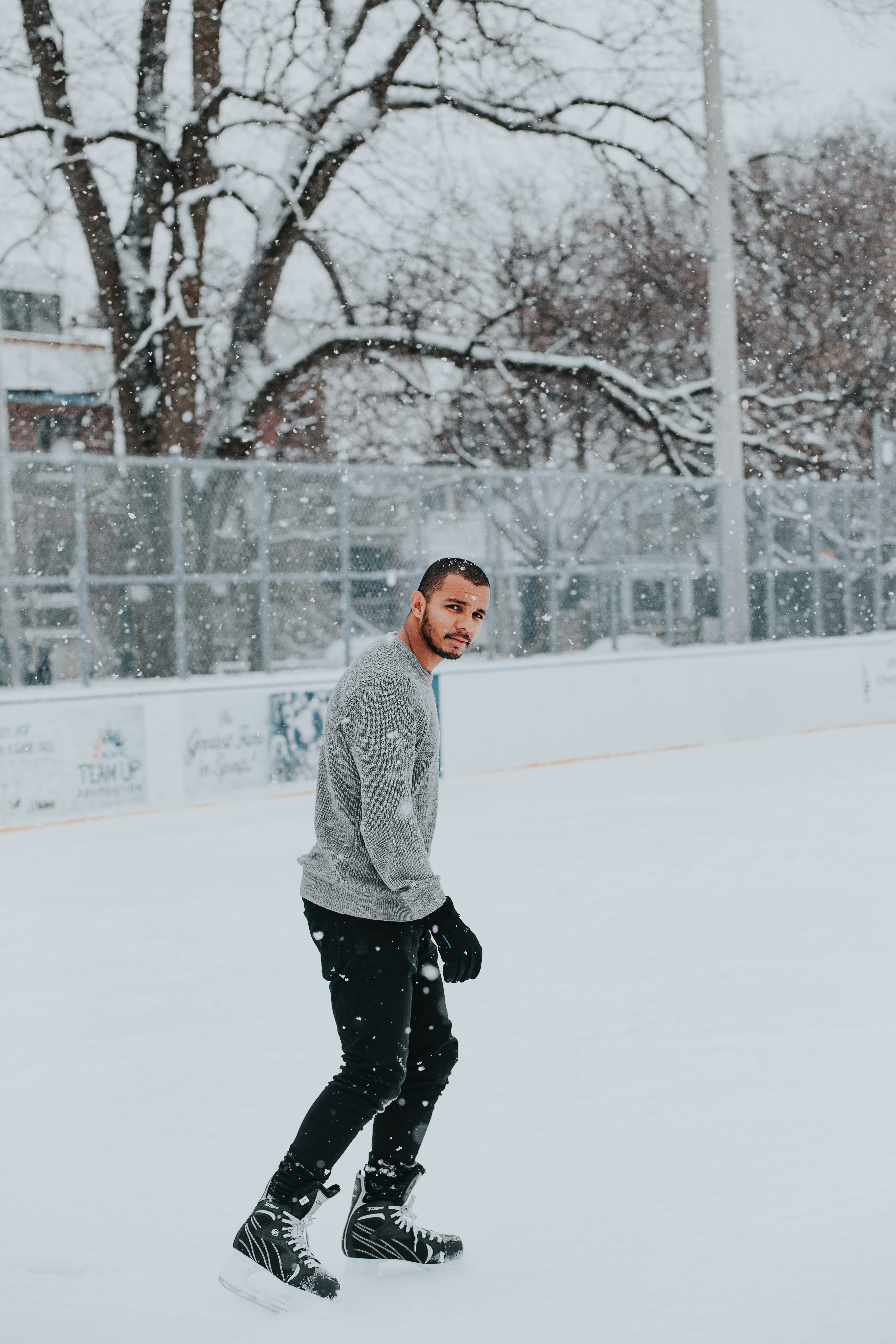 man in gray sweater walking on snow
