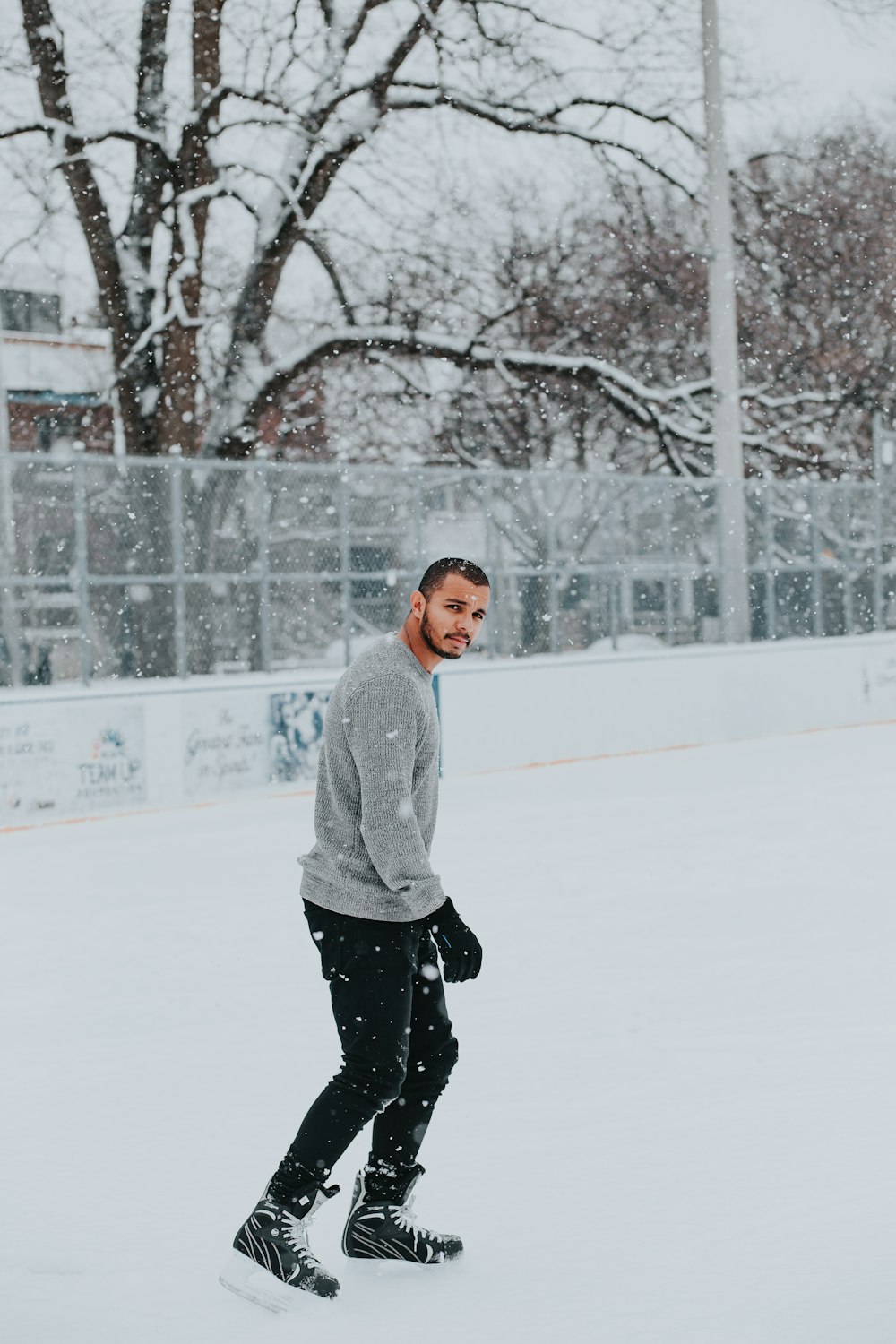 man in gray sweater walking on snow