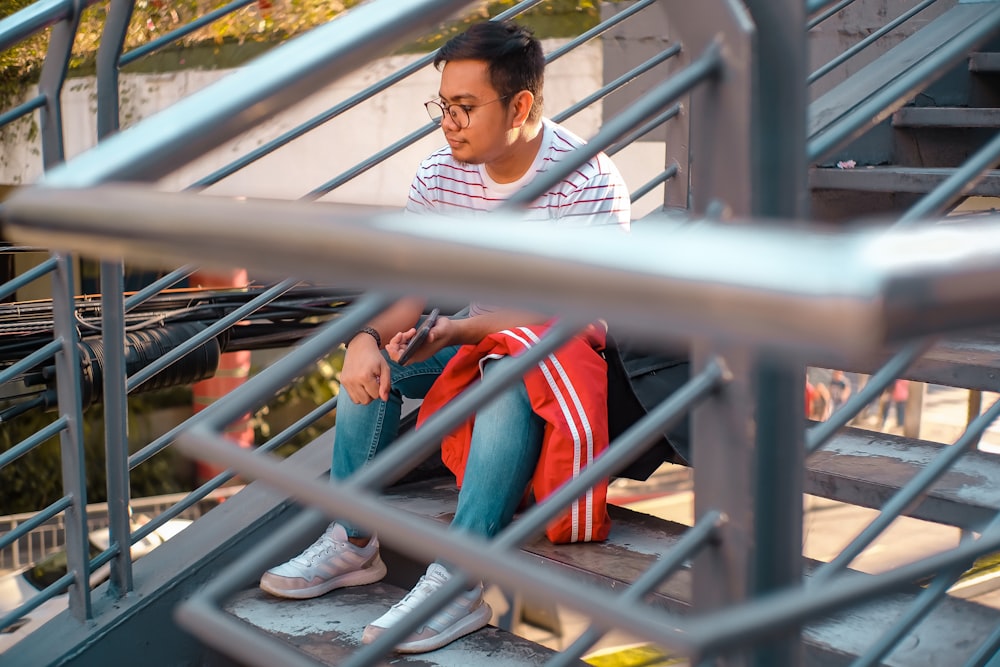 homme assis sur des escaliers en métal