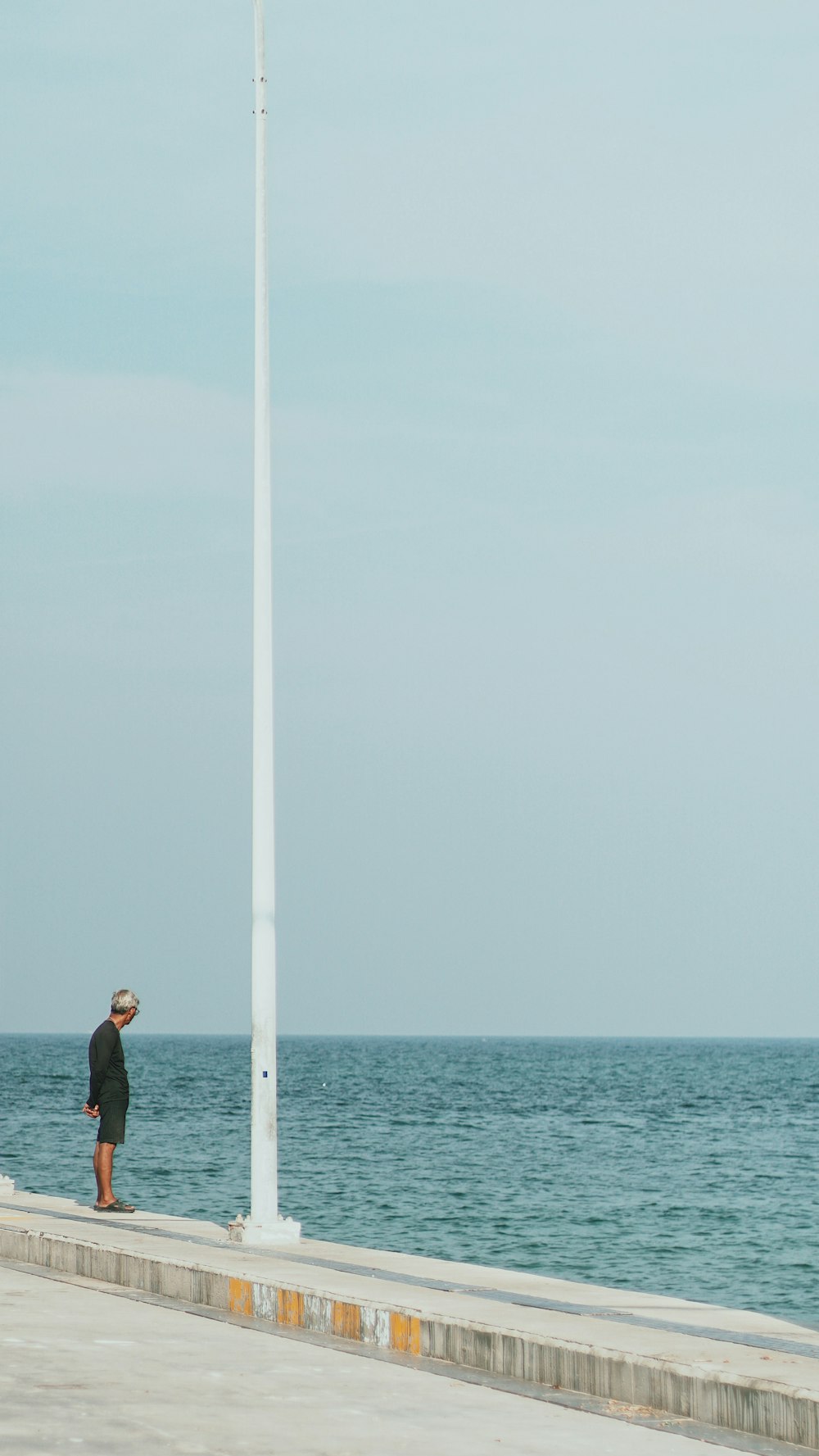 uomo in piedi accanto allo specchio d'acqua