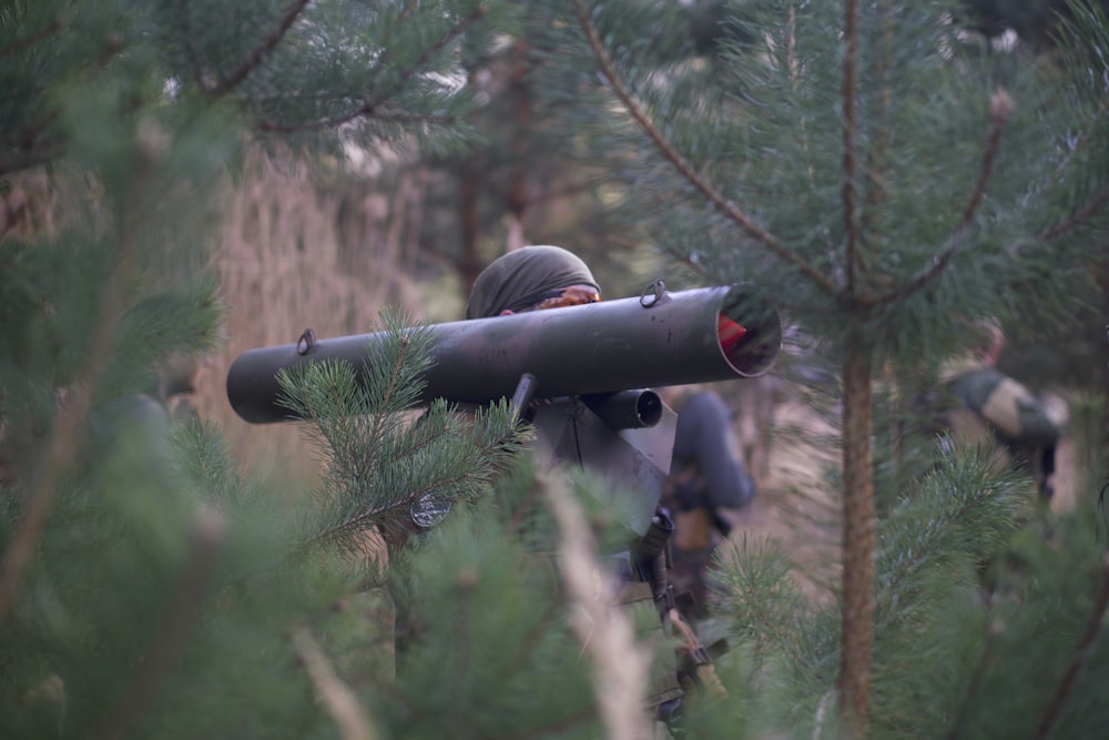 man holding missile while standing near green field