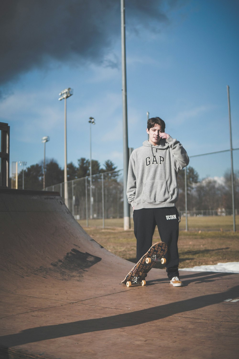 man in gray hoodie with kateboard