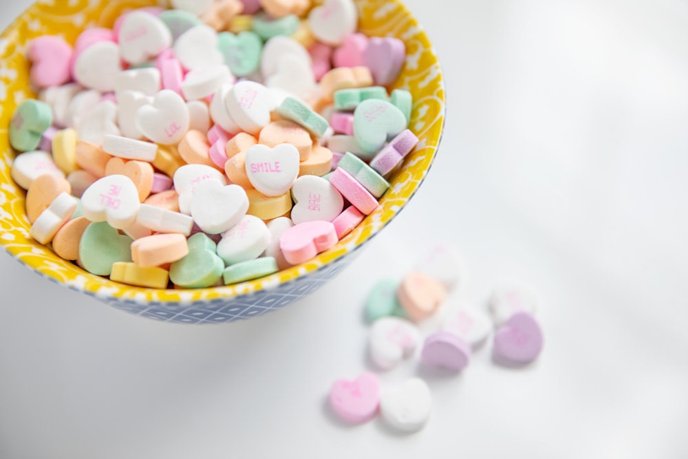 minimalist photography of bowl of variety colored heart-shaped candies