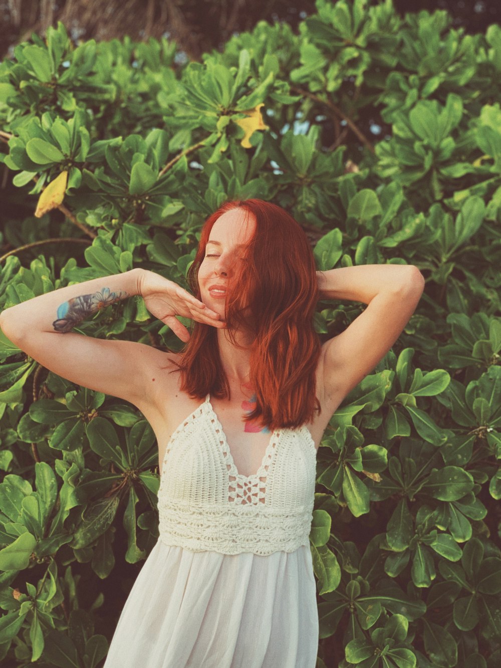 woman standing beside a green-leafed tree