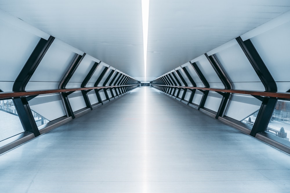 a long hallway with a metal railing and windows