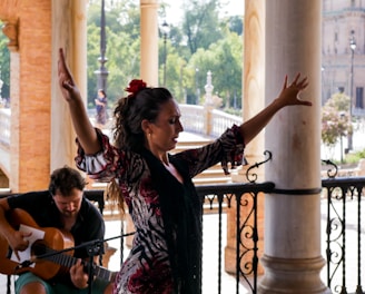 woman dancing and man playing acoustic guitar indoors