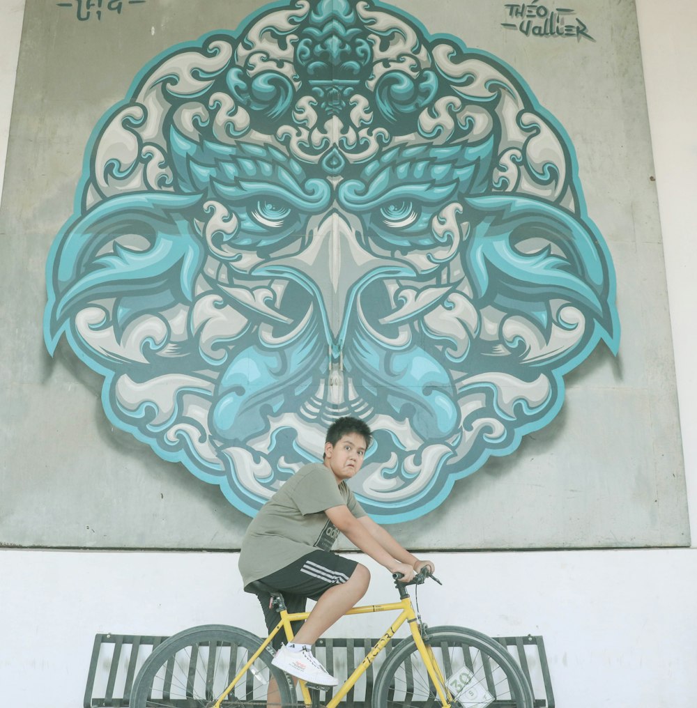 man riding yellow bicycle