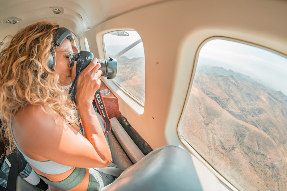 woman holding camera taking photo outside vehicle