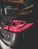Rear view of the Tesla Model 3 with distinctive taillights illuminated