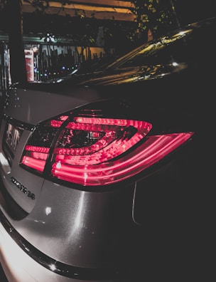 Rear view of the Tesla Model 3 with distinctive taillights illuminated