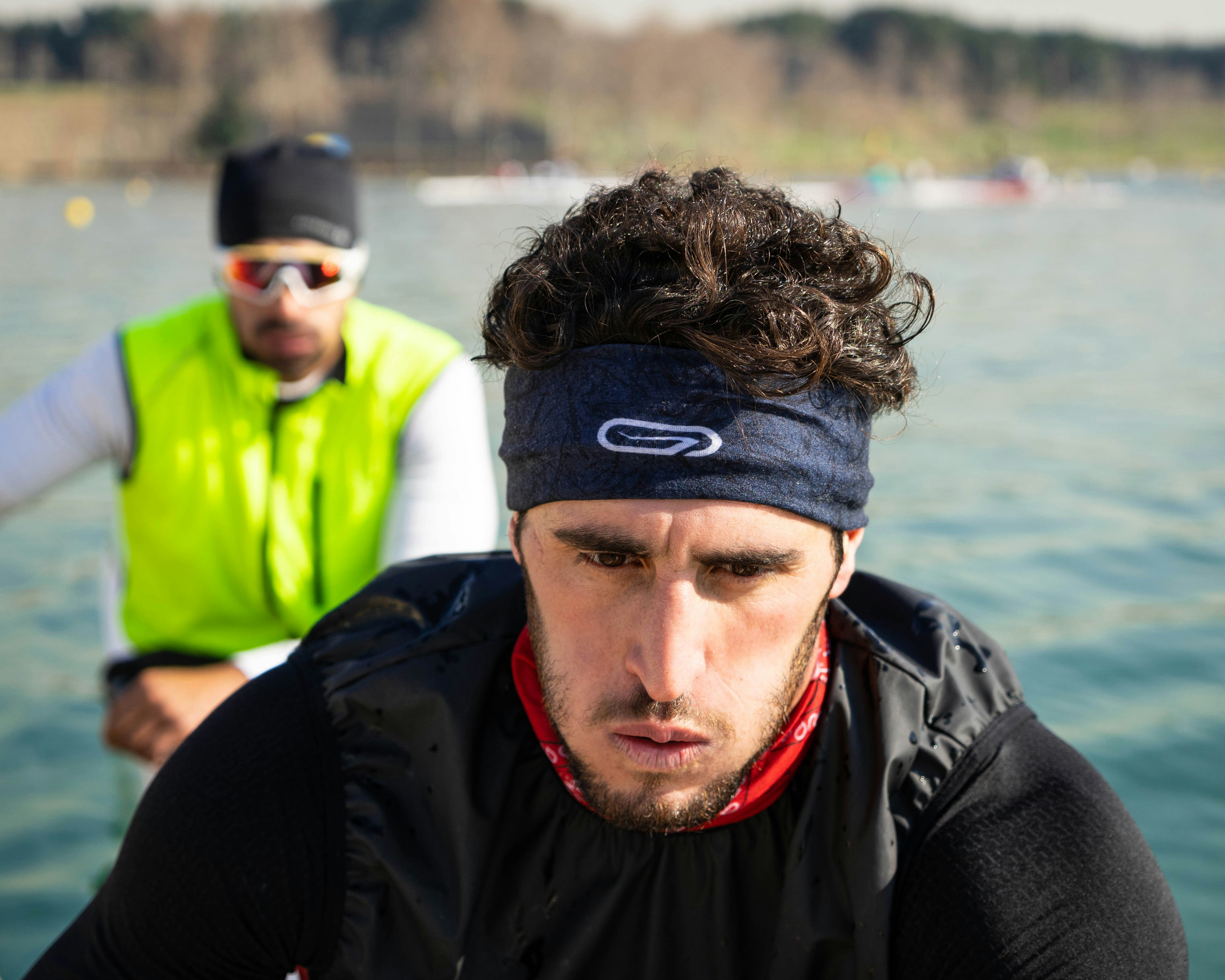 two men riding boat wearing black and green tops, 