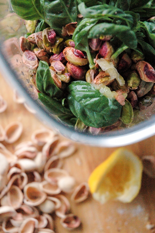 A blender filled with spinach and other ingredients