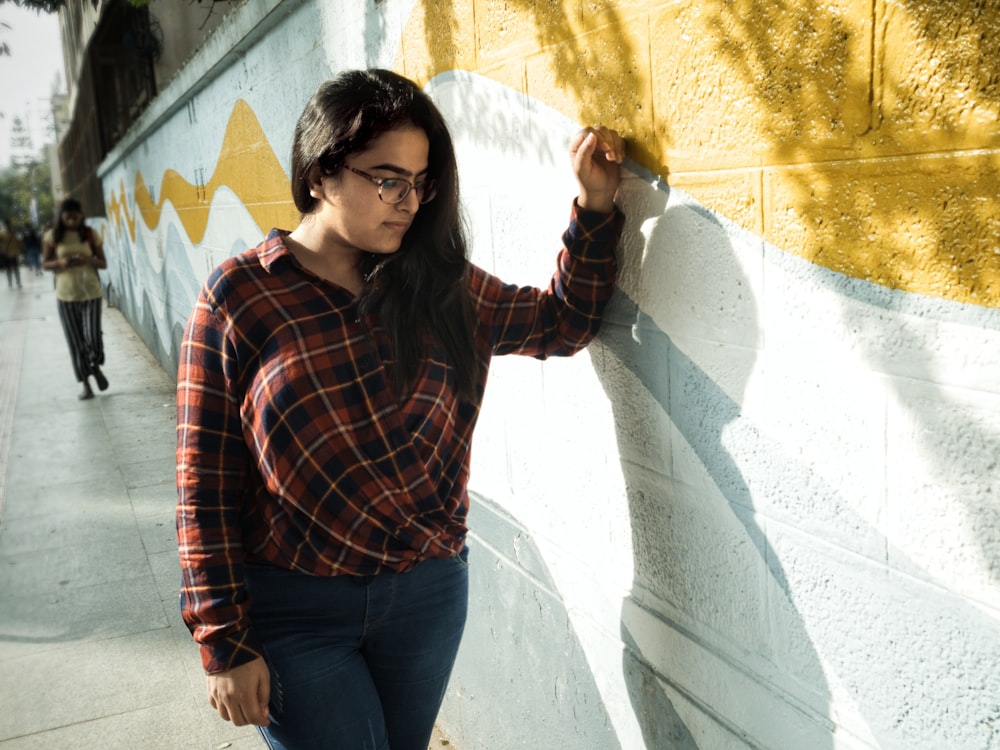 woman standing in front of brown and white painted concrete wall