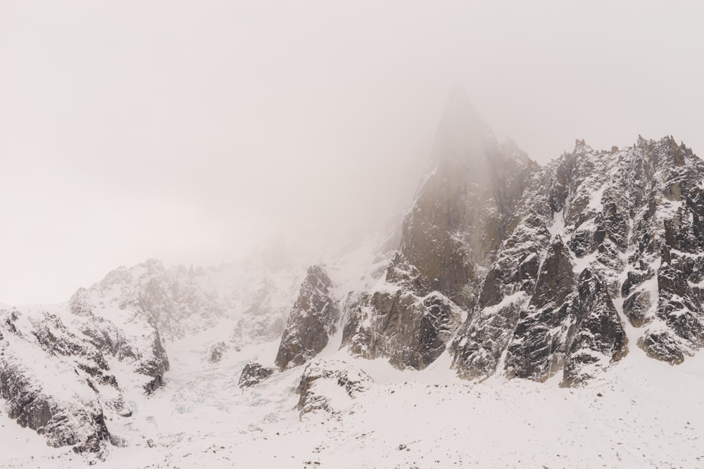 field and mountain covered with snow in foggy day