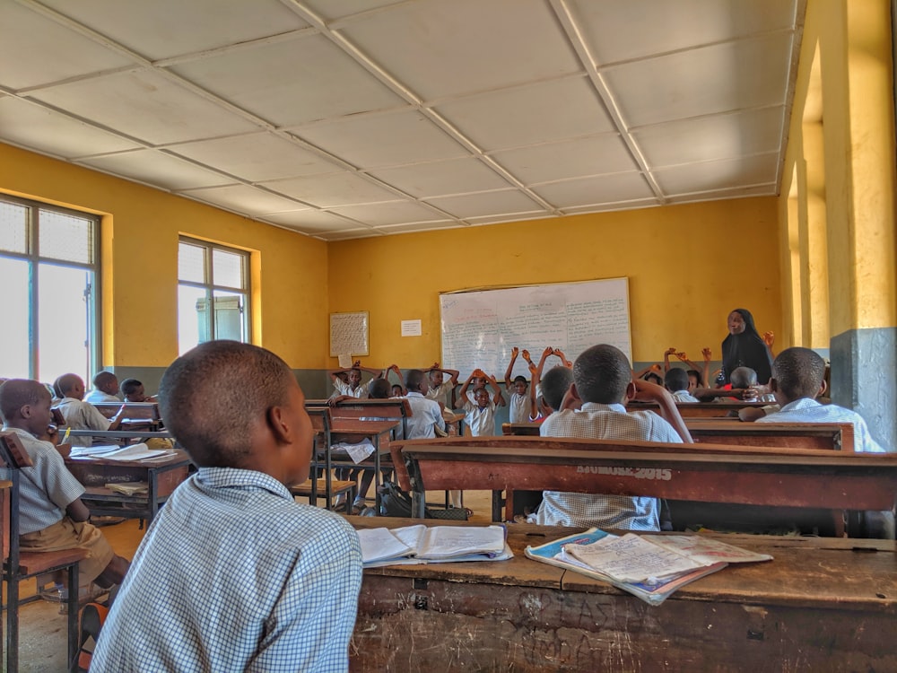 kids inside room listening to a nun by whiteboard at daytime