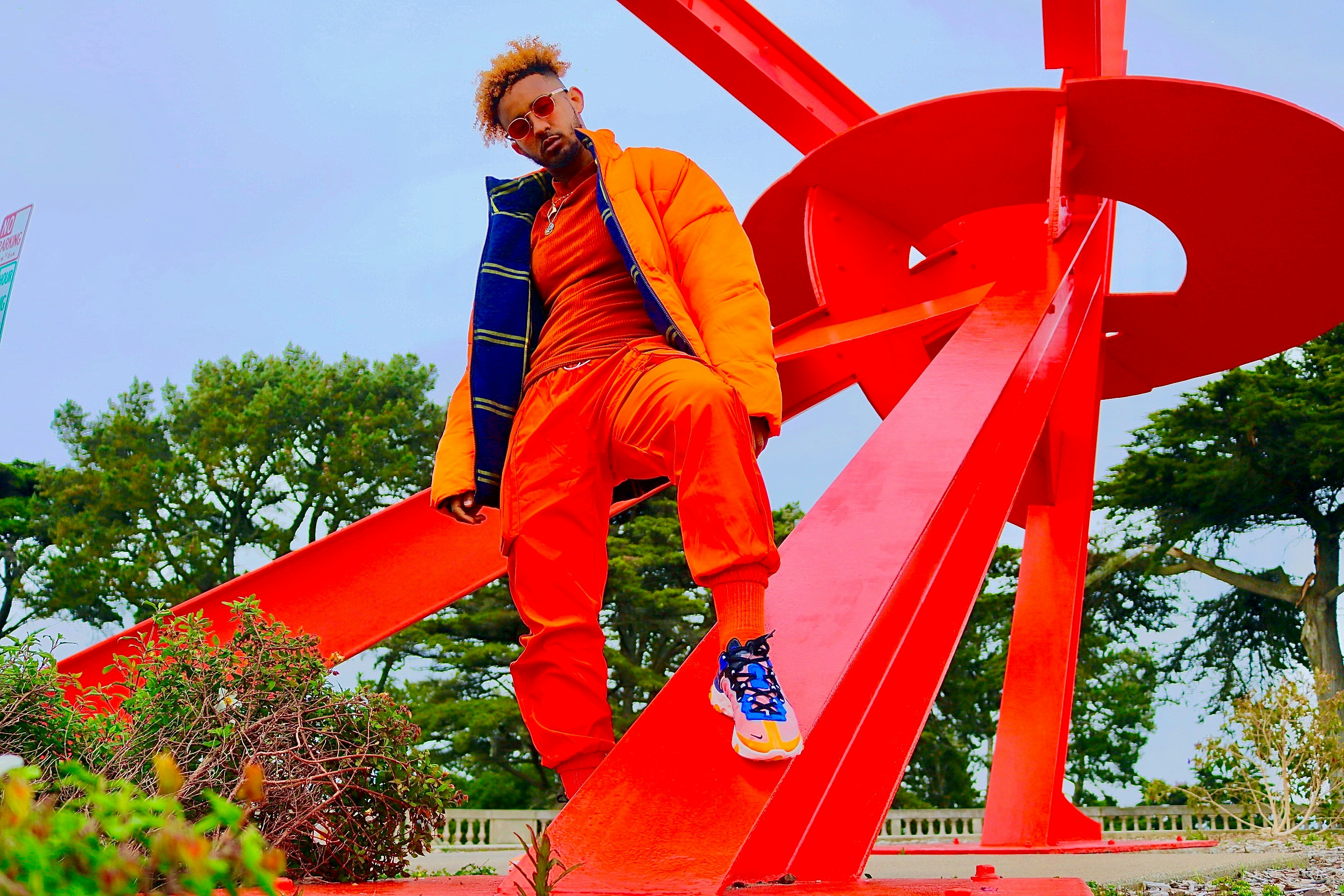 man standing on red metal frame during daytime