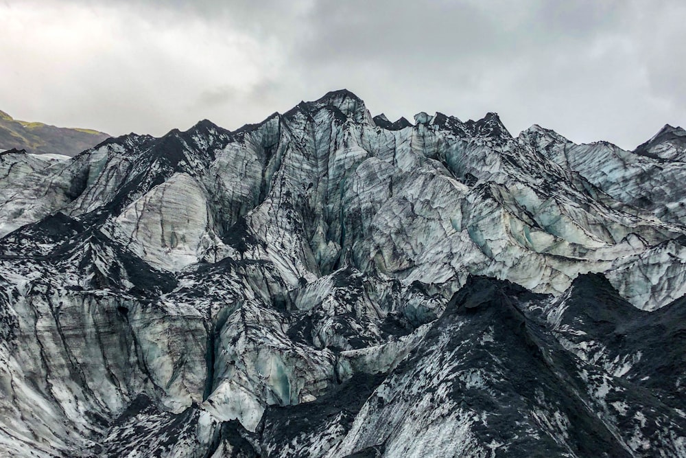 gray rocky mountain under cloudy sky during daytime