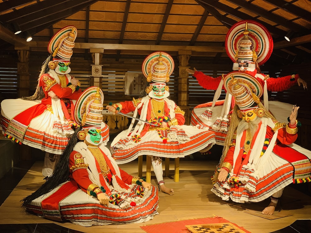 five people wearing multicolored costumes while dancing