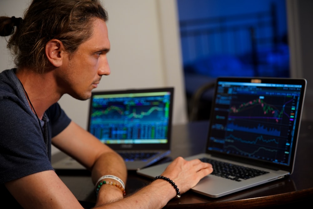 man sitting in front of the MacBook Pro