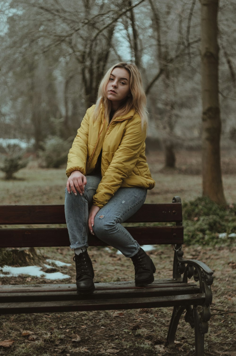 woman in yellow jacket sitting on bench