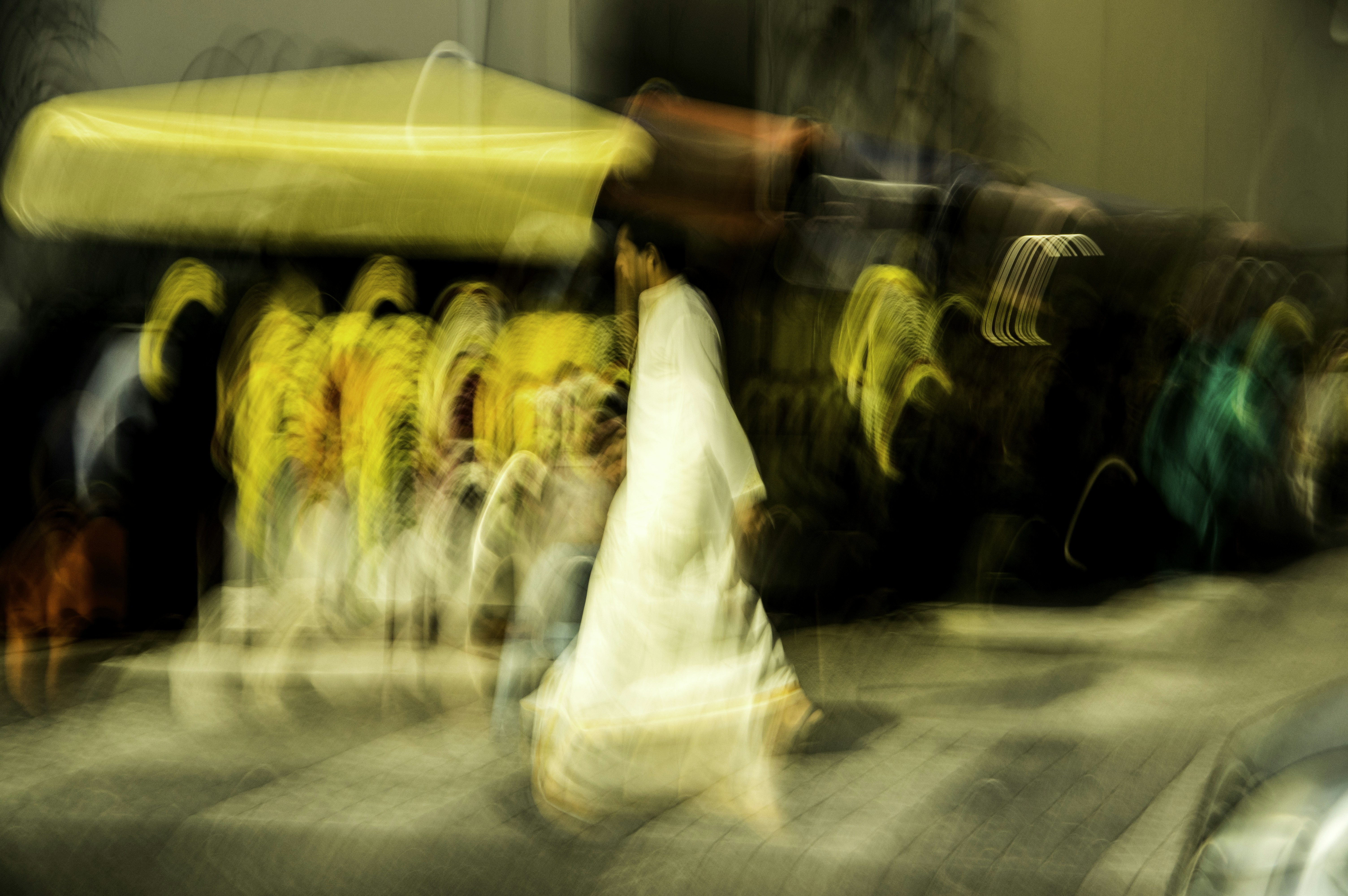 Mann in weißem Thobe geht nachts auf der Straße
