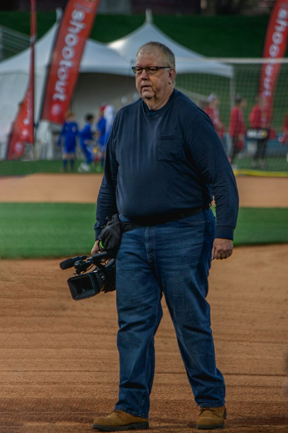 man in black long sleeve shirt and blue denim jeans holding black and orange golf club