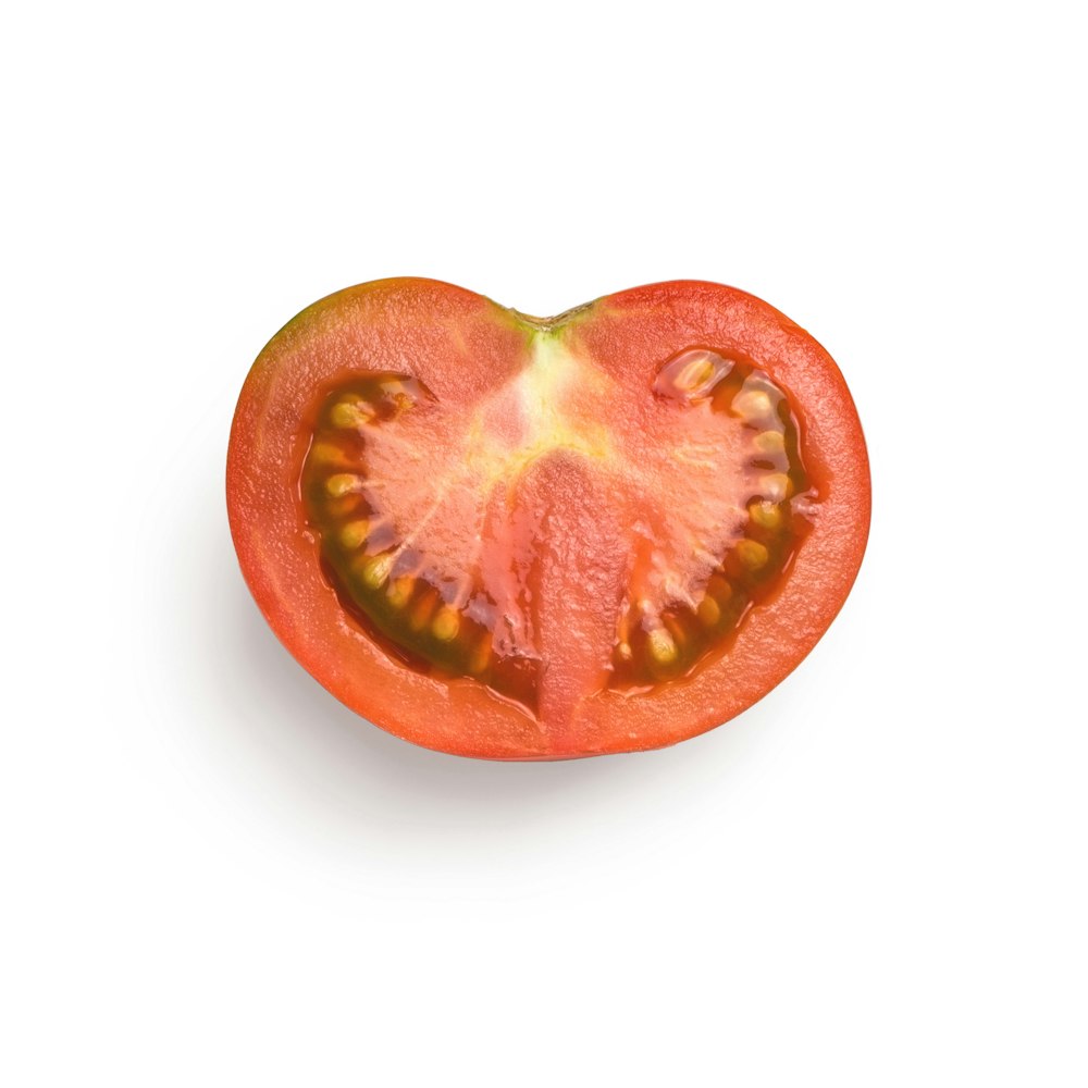 a tomato cut in half on a white background