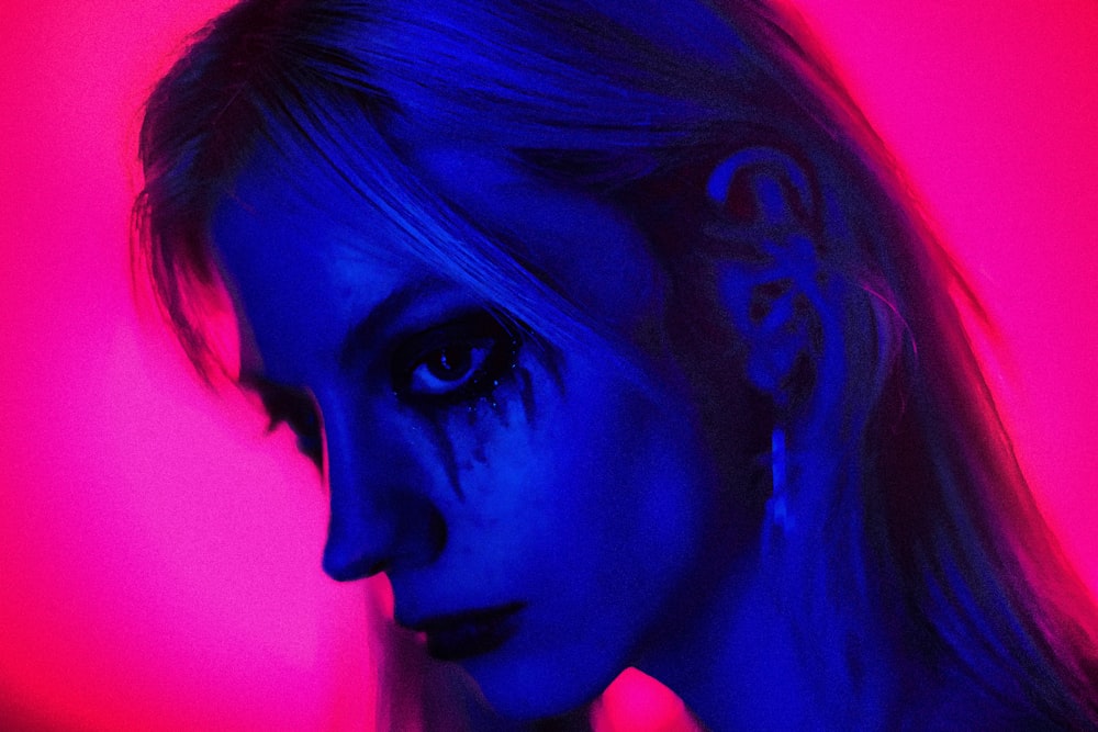 a woman in a dark room with a red and blue background