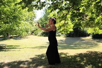 A graceful Tai Chi instructor moving slowly in a peaceful garden.