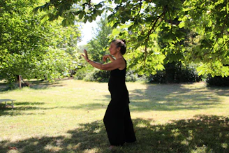 A serene studio space with Heng Hu guiding a client through a slow, focused qigong movement.
