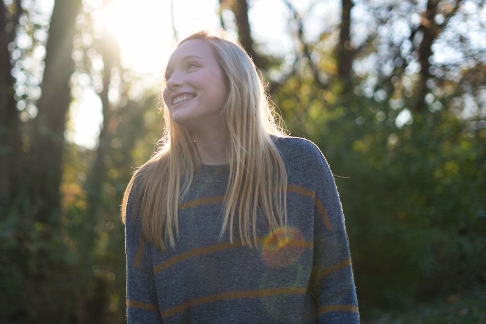 woman in gray and yellow striped sweater smiling