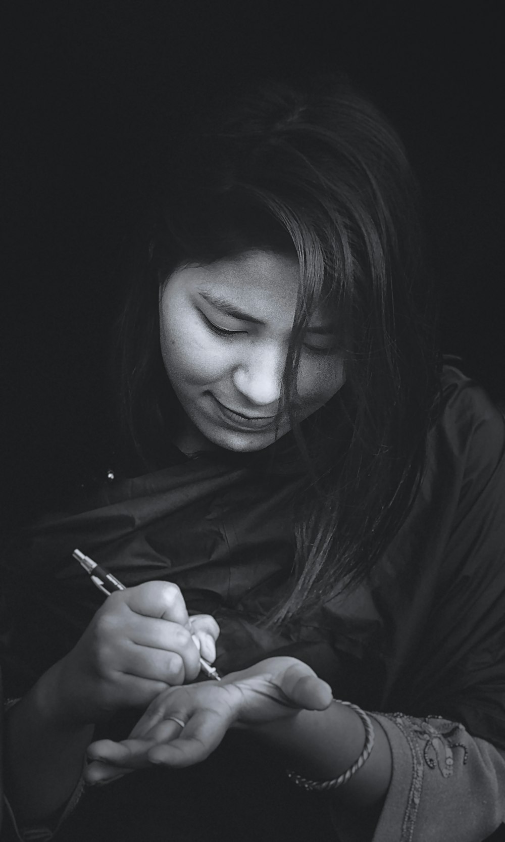 woman in black jacket holding pen