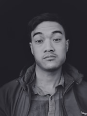 A sharp, minimalist business headshot featuring a person in smart attire against a clean white background.