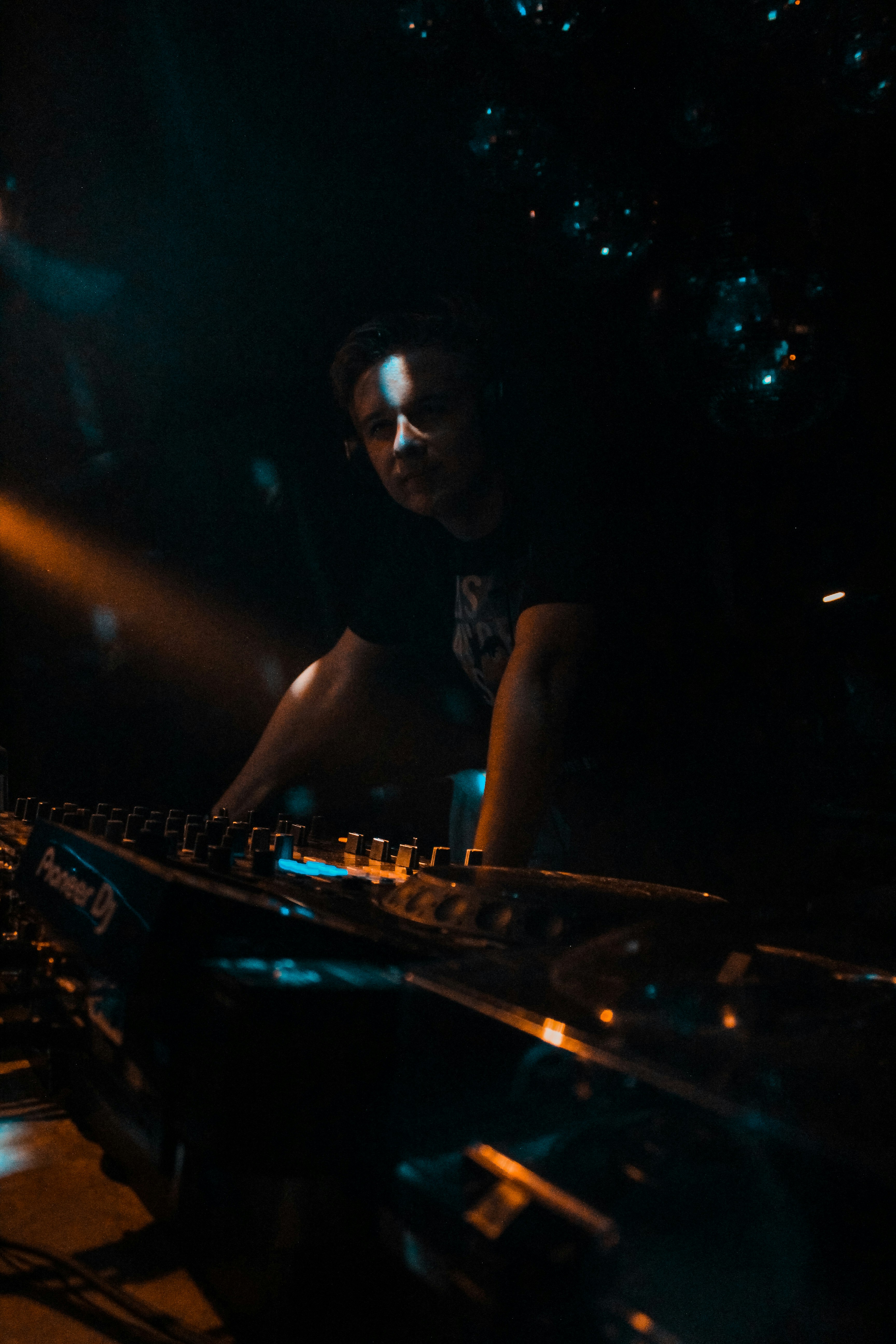 暗い部屋で音楽をミックスするDJ