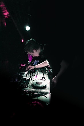 Dark industrial DJ mixing live with neon purple glitch effects in a gritty underground club.