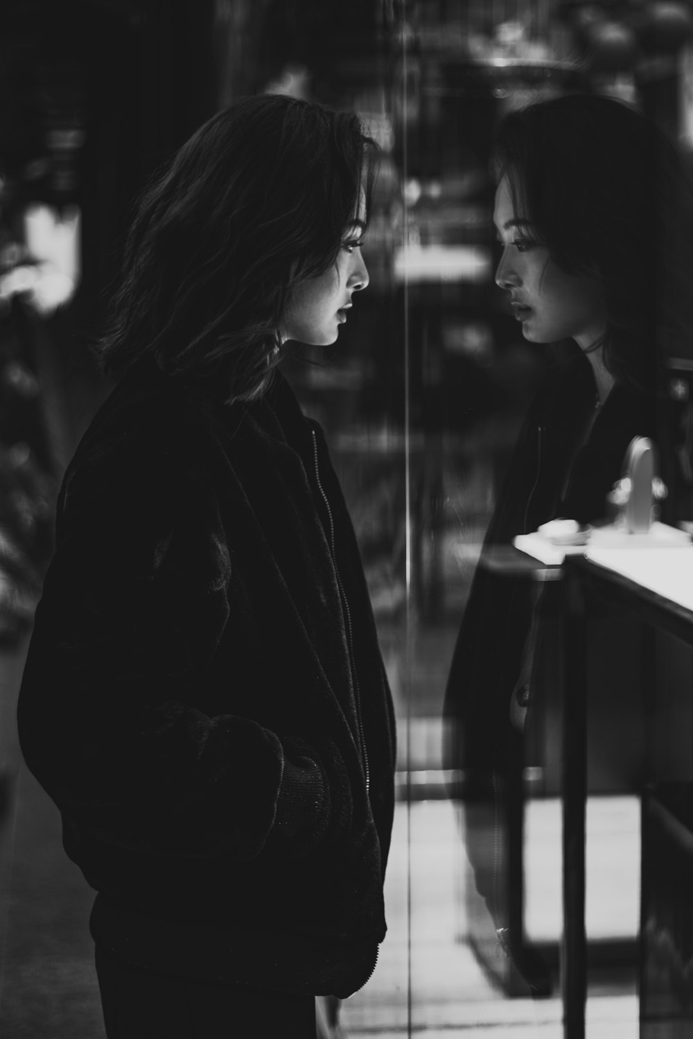 woman in black coat standing beside table