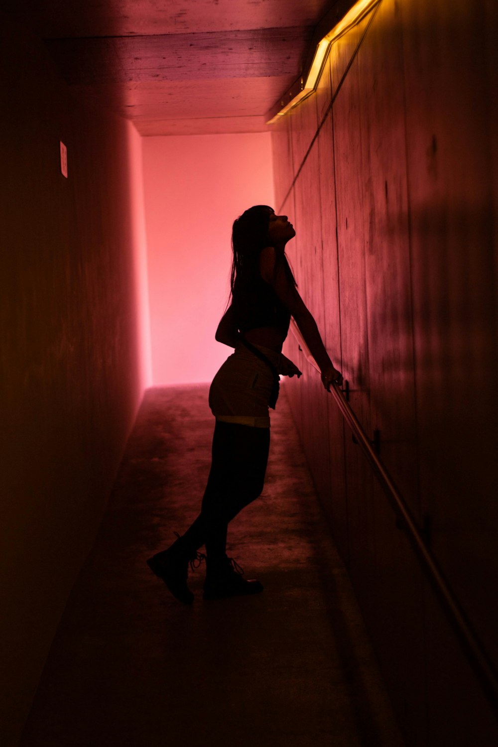 woman in black tank top and black pants standing on brown wooden floor