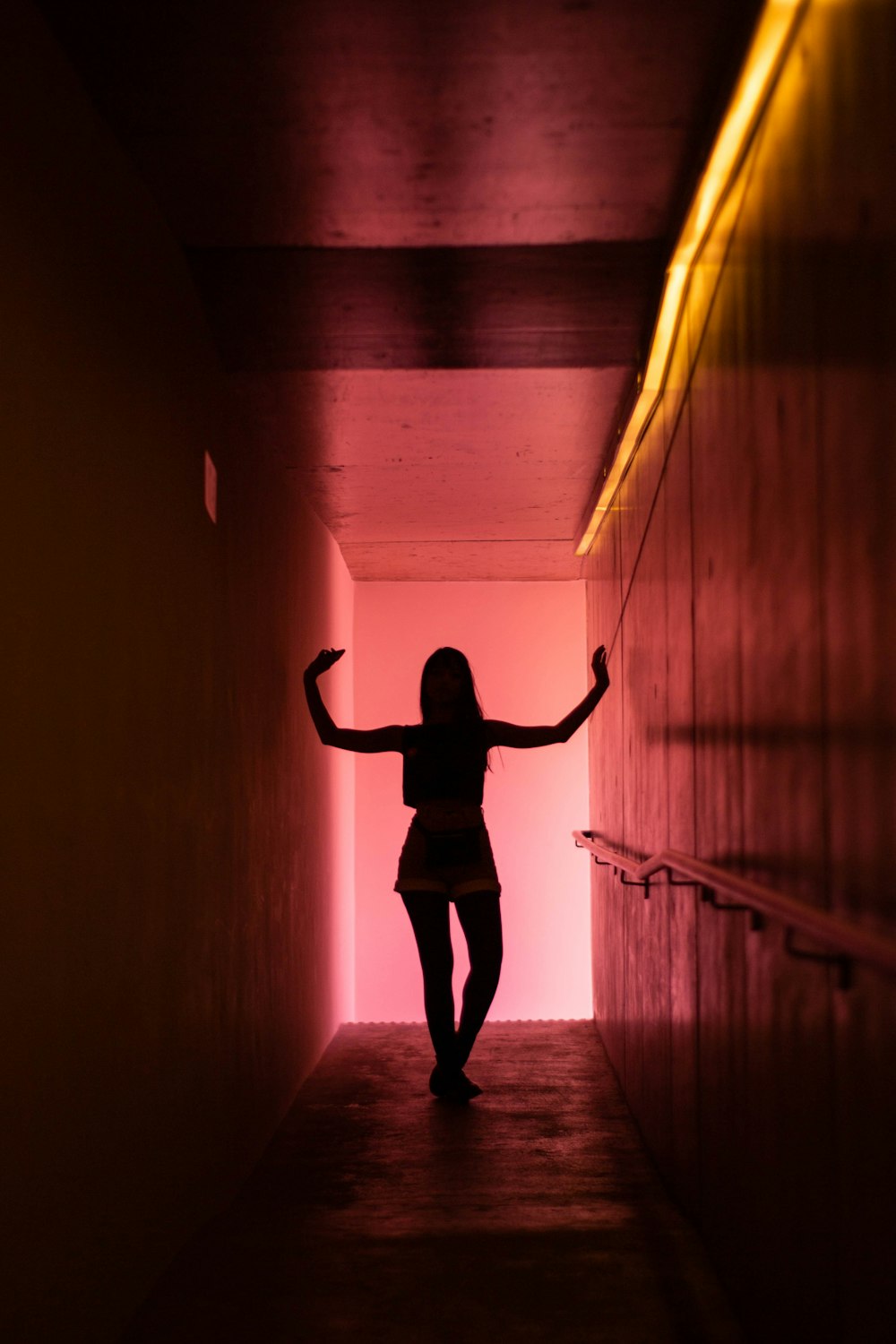 woman in black long sleeve shirt and black pants standing on tunnel